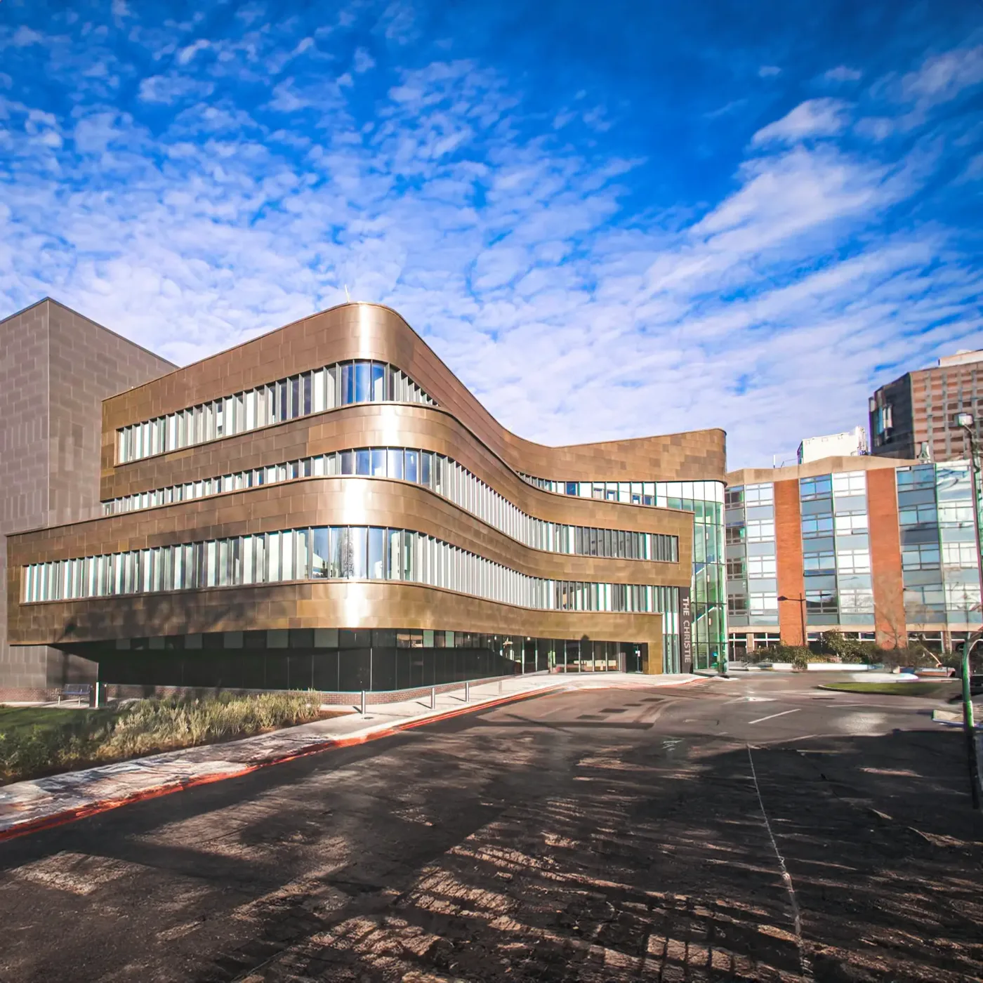 A modern hospital building under a blue sky