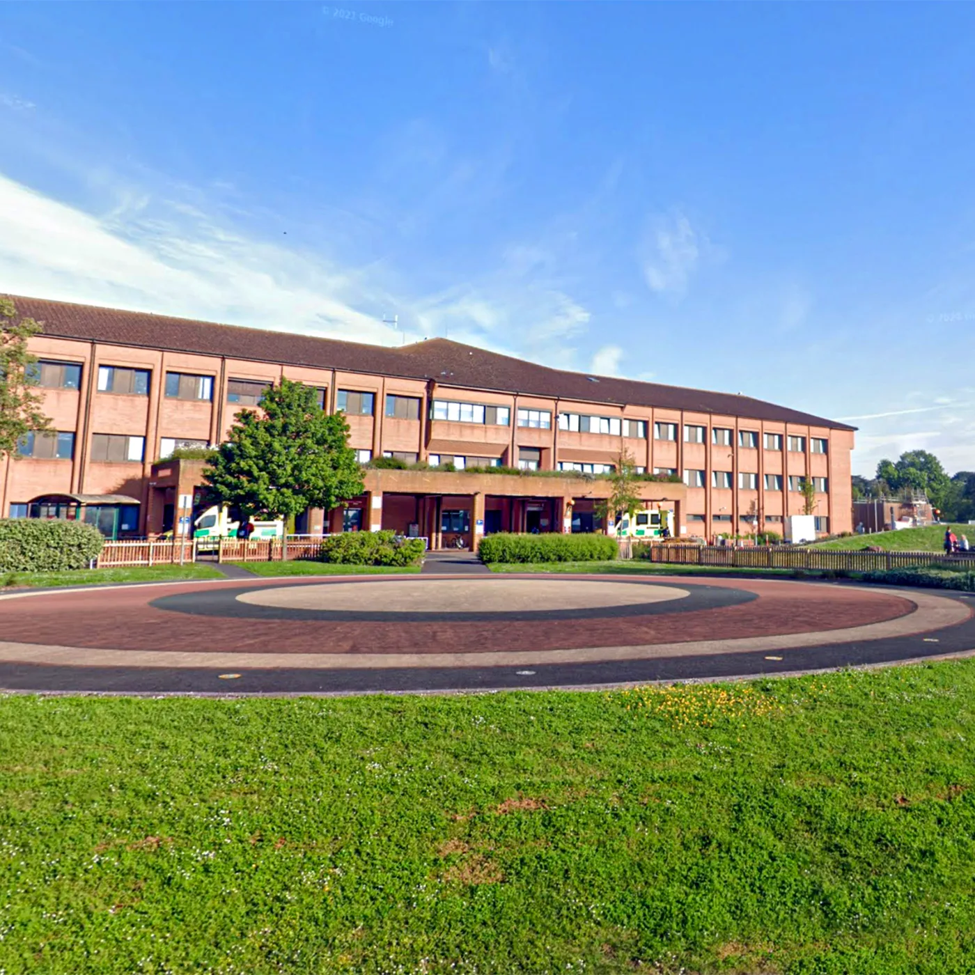 A hospital building behind a green lawn